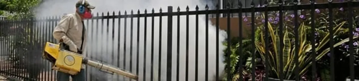 Mosquito control technician fogging a yard perimeter for mosquito reduction in Mobile, AL